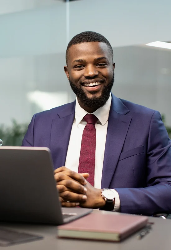 cheerful-black-businessman-posing-at-workdesk-in-o-2025-03-18-18-16-20-utc