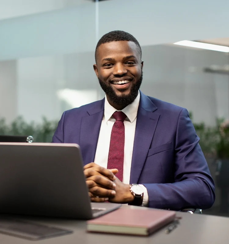 cheerful-black-businessman-posing-at-workdesk-in-o-2025-03-18-18-16-20-utc